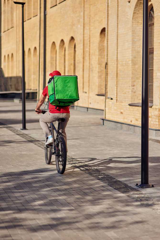 delivery-man-with-refrigerator-bag-riding-bicycle-2021-10-26-01-35-27-utc.jpg