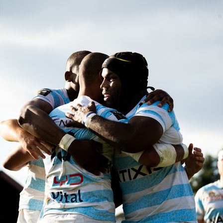 Racing 92 players hug each other after a game action, celebrating points scored.